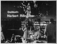 Spielfeld und Bühne in der Kongreßhalle Hannover, Juni 1967. Im Hintergrund: Rückwände der Wohnung KLIESS, die komplett mit Bewohnern auf die Bühne gebracht ist. In der Wohnung Besucher. Im Mittelgrund Schriftprojektion aus der Titelei eines deutschen Serienkriminalfilms, der als Deutungsfolie (durchsichtig) auf das Geschehen in der Wohnung KLIESS projiziert wird. Im Vordergrund Aktion 'Die Wegwerfbewegung'.