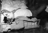 Bazon Brock, auf einem Bett liegend